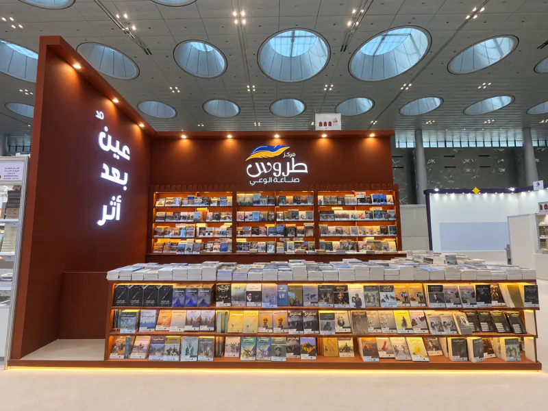 Retouched front view of the Torous Publishing stand with illuminated book displays and Arabic branding