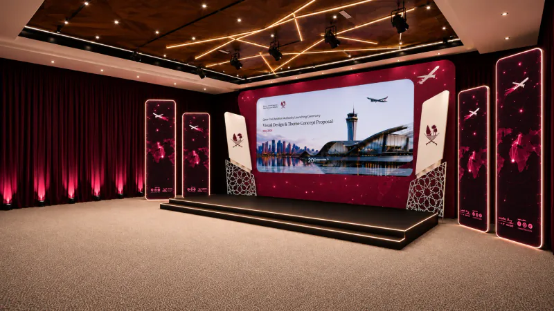 Photorealistic architectural render of the QCAA strategy launch stage from an oblique angle, with burgundy displays and illuminated stage steps